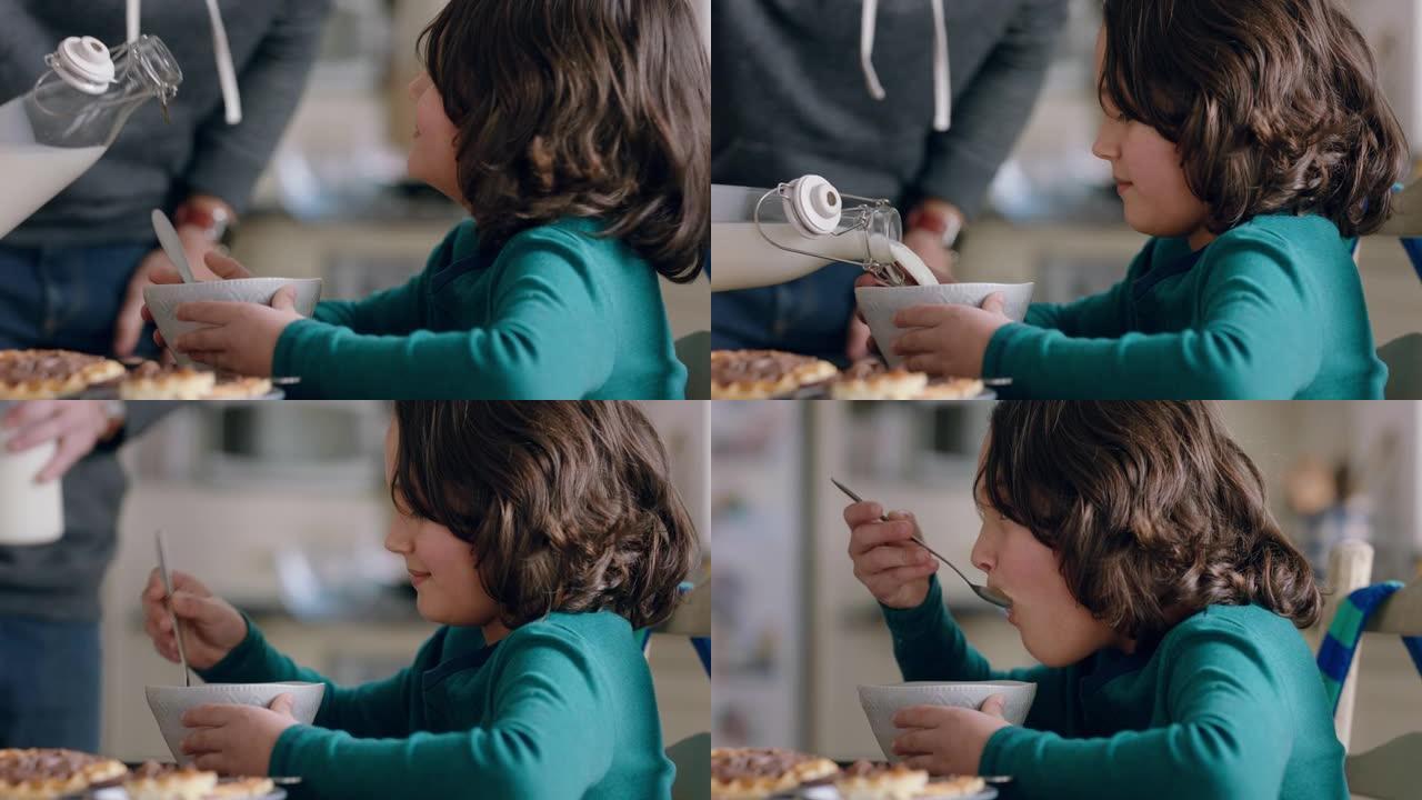 快乐的小男孩在厨房吃早餐，父亲把牛奶倒入麦片碗，享受在家照顾儿子的乐趣