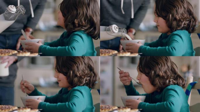 快乐的小男孩在厨房吃早餐，父亲把牛奶倒入麦片碗，享受在家照顾儿子的乐趣