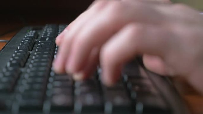 一个年轻人在笔记本电脑键盘上打字的特写镜头