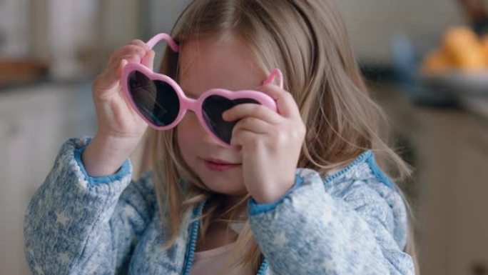 肖像美丽的小女孩戴着可爱的太阳镜在家里玩得开心，穿着打扮享受童年的想象力