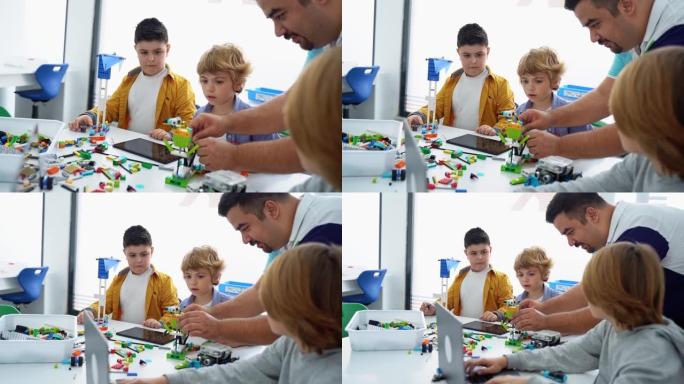 机器人编程课。儿童构造和编码机器人。使用构造器块和笔记本电脑平板电脑、遥控操纵杆的STEM教育。面向