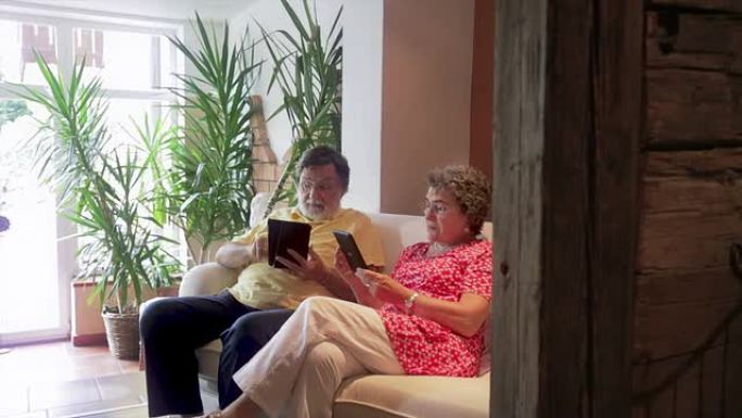 富有的高级夫妇正在家里阅读电子书