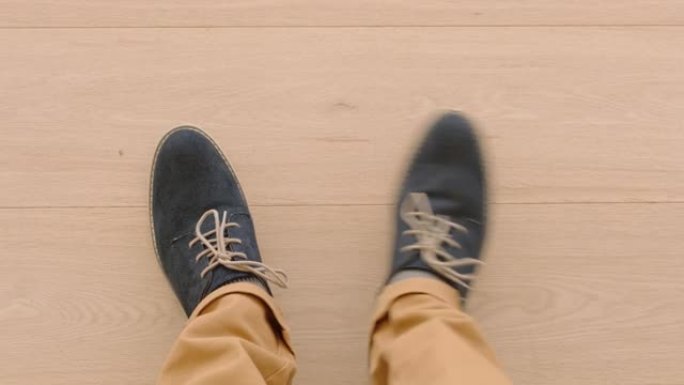 上图男人穿着鞋子，站在木地板上享受时尚的鞋