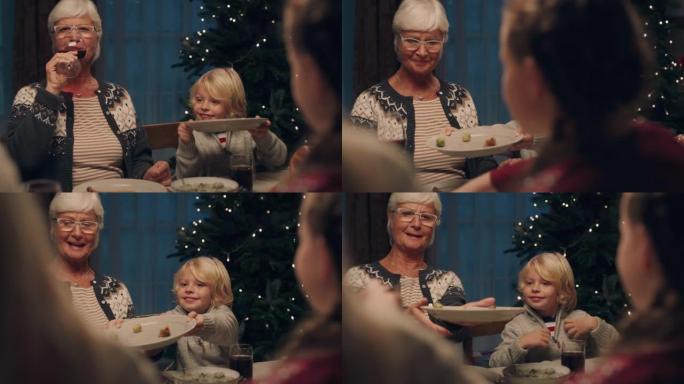 祖母和孙子一起享受圣诞晚餐，吃美味的家常便饭，与家人在家分享节日盛宴4k镜头