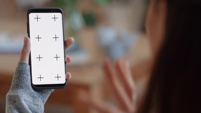 使用智能手机绿屏进行视频聊天的女人在色度键上向朋友挥手，享受垂直方向的手机通信显示4k