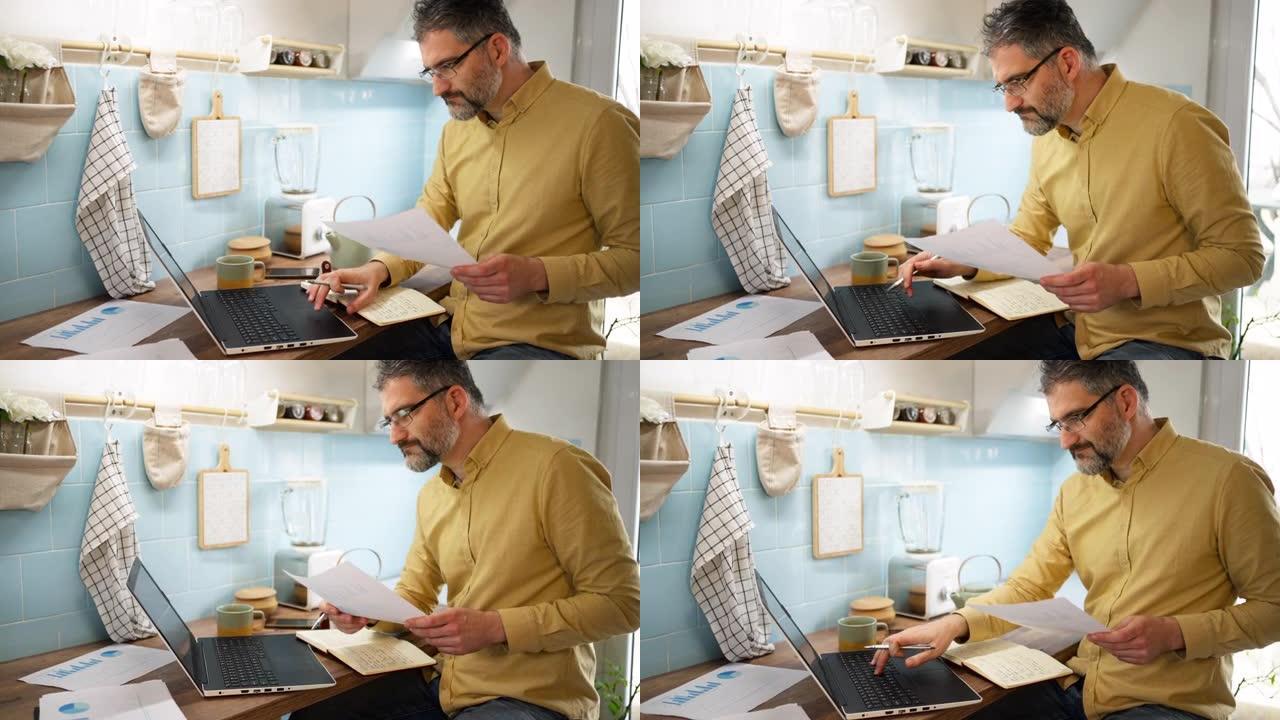 白人男子在厨房里用笔记本电脑工作