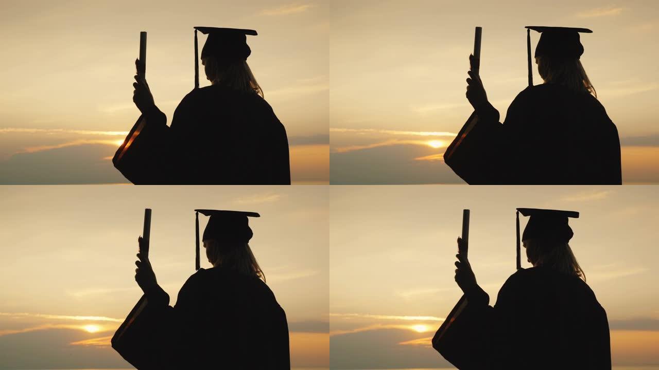 一名高中毕业生手里拿着文凭的剪影映衬着天空