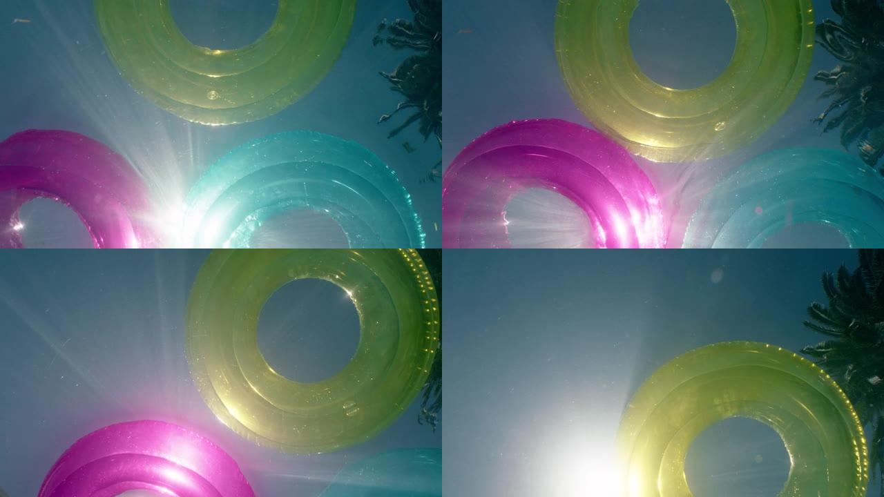pov彩色游泳漂浮在游泳池多色充气水甜甜圈玩具与美丽的阳光照耀夏日水下视图pov 4k