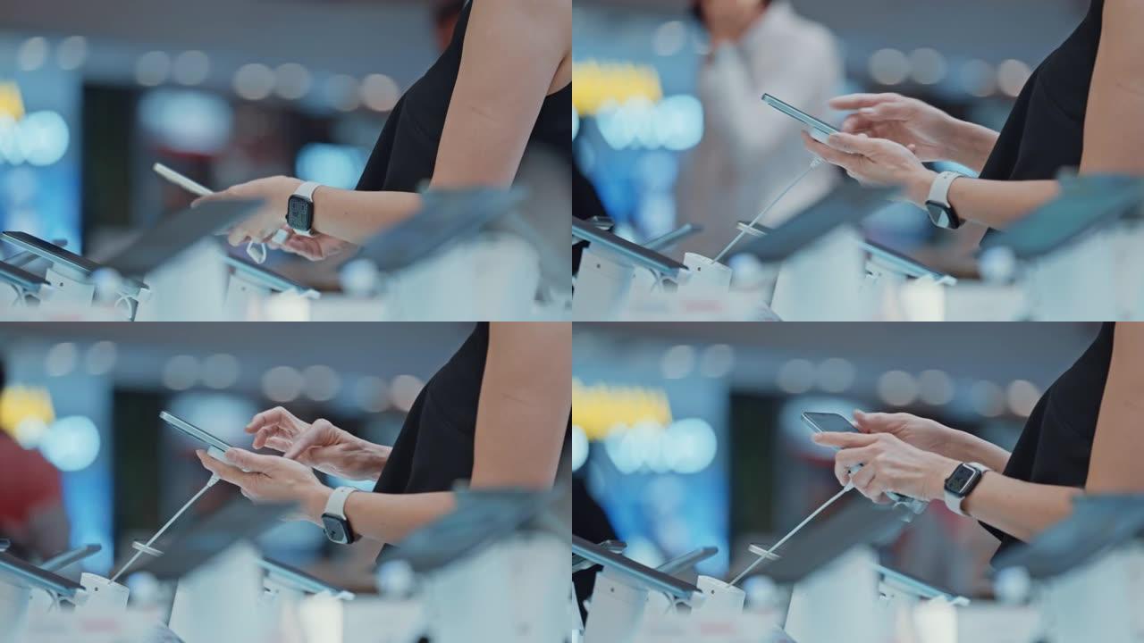 女人选择在电子商店购买新智能手机的手的特写