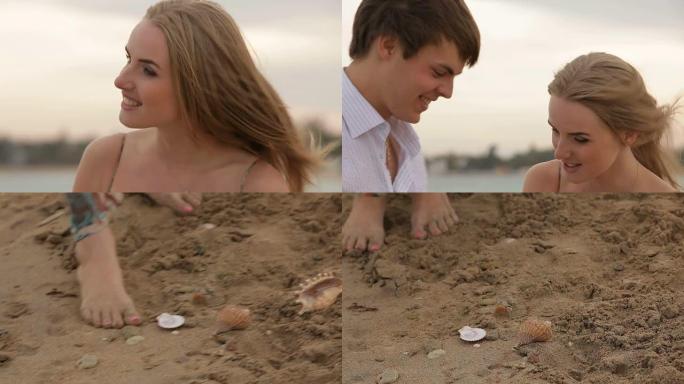 年轻夫妇在海滩上收集贝壳