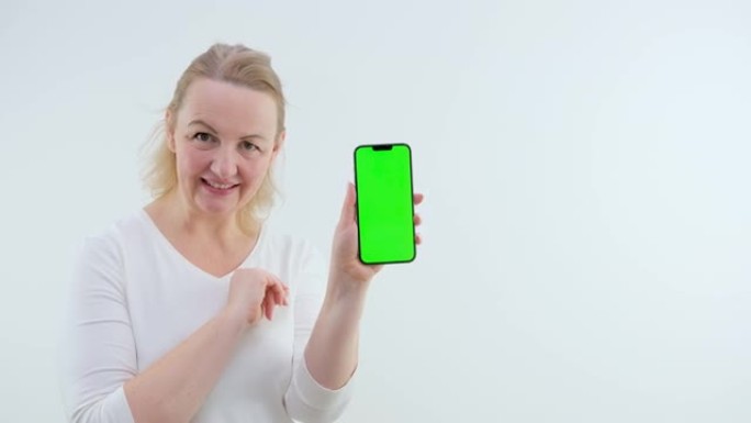 成年女性绿屏手机chromakey空间文字笑跳舞欢欣鼓舞展示双手Poof Abracadabra竖起