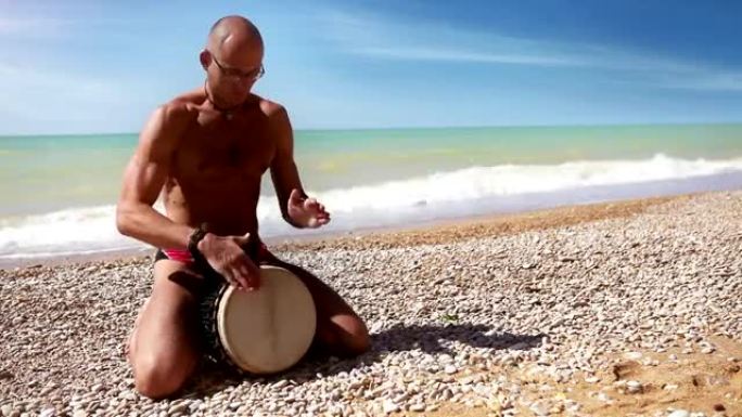 Djembe传统鼓手在孤独的海岸击败rythm