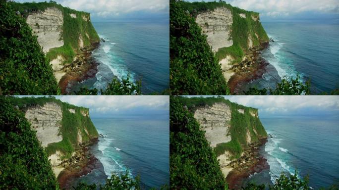 巴厘岛原始热带绿色海滩的电影景观，巨大的悬崖深渊和无尽的海洋地平线。暑假假期。巴厘岛海水和岩石海岸线