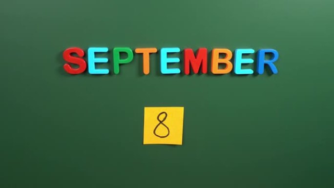 9月8日日历日用手在学校董事会上贴一张贴纸。8 9月日期。9月的第八天。第8个日期号。8天日历。八次