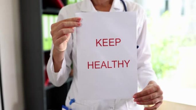 带有文字的纸保持健康在治疗师医生手中