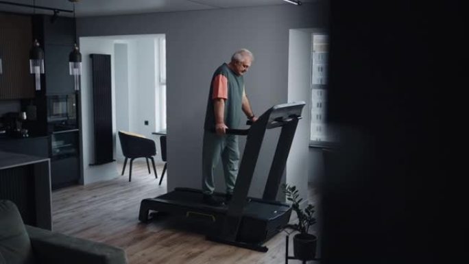 成熟的男人使用跑步机来挽救健康和保持健康，独自在家训练