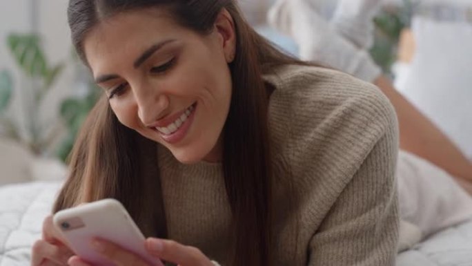 美女使用智能手机躺在床上发短信浏览社交媒体信息享受手机在家放松4k镜头