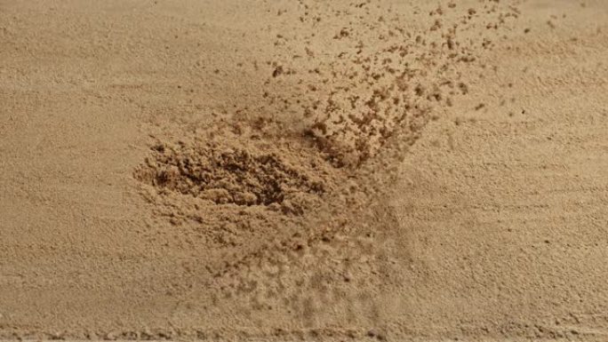 SLO MO LD子弹从侧面击中沙子并导致沙子飞向空中