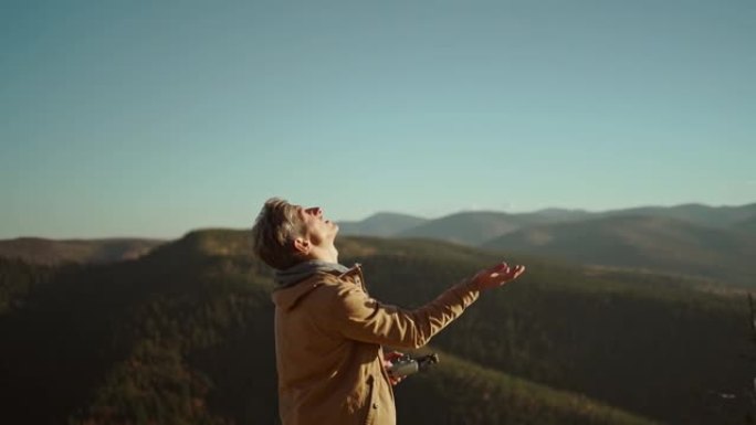 专业的空中摄像师飞行员准备降落无人机。飞行员和控制器在空中发射直升机，起飞，飞起来。松林和山地景观