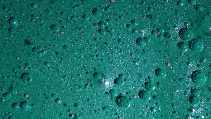 珍珠漆和气泡的抽象液体蓝绿色漩涡的俯视图。油墨，油球。五颜六色的形状。详细的纹理背景，漂亮的设计。