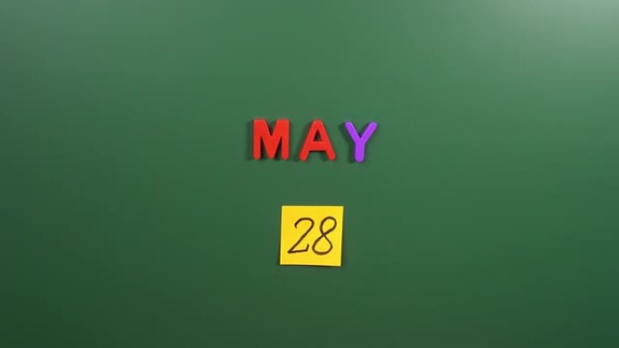 5月28日日历日用手在学校董事会上贴一张贴纸。5月28日。五月的第二十八天。第28个日期号。28天日