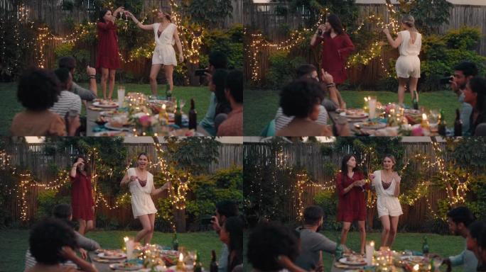 朋友在晚宴上跳舞庆祝美丽的女人一起跳舞，享受周末在家里4k后院聚会的乐趣