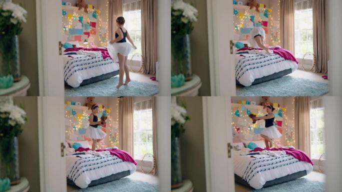 快乐的少女穿着芭蕾舞短裙在床上跳舞，在卧室里和泰迪熊一起跳舞