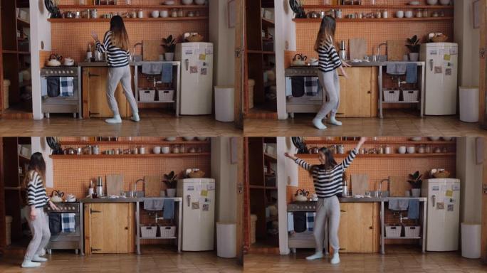 快乐的女人在厨房跳太空步庆祝成功的生活方式享受快乐的胜利舞蹈庆祝周末在家里