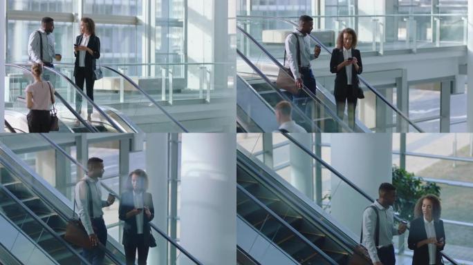 自动扶梯上的商人聊天非裔美国商人与女高管同事交谈，讨论公司办公室大堂的工作4k