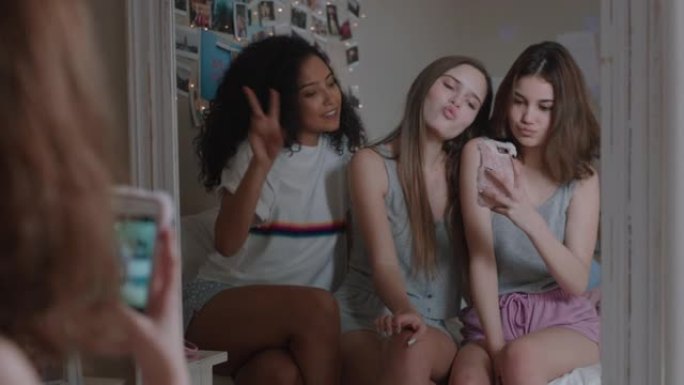 快乐的十几岁的女孩一起用智能手机自拍照片最好的朋友摆姿势享受在社交媒体上在家闲逛分享周末