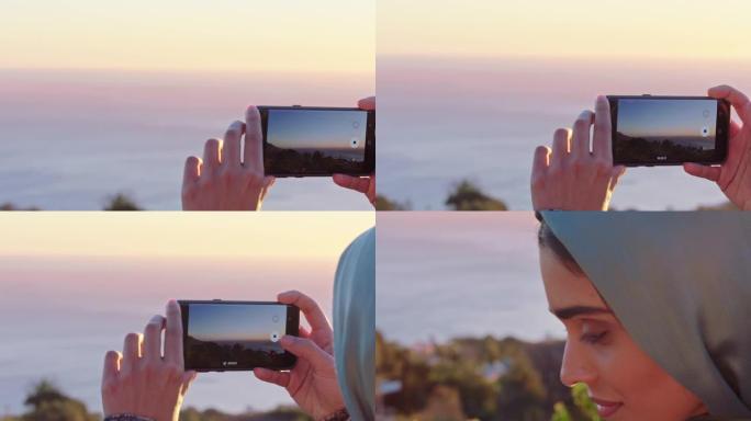 关闭穆斯林妇女使用智能手机拍照日落时拍摄美丽的海洋享受旅游生活方式度假观光