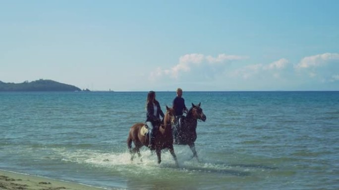 一对穿着便装的幸福夫妇的肖像在海边骑着小跑和奔马在水中奔跑。男女马术享受天气、自然和清新的微风