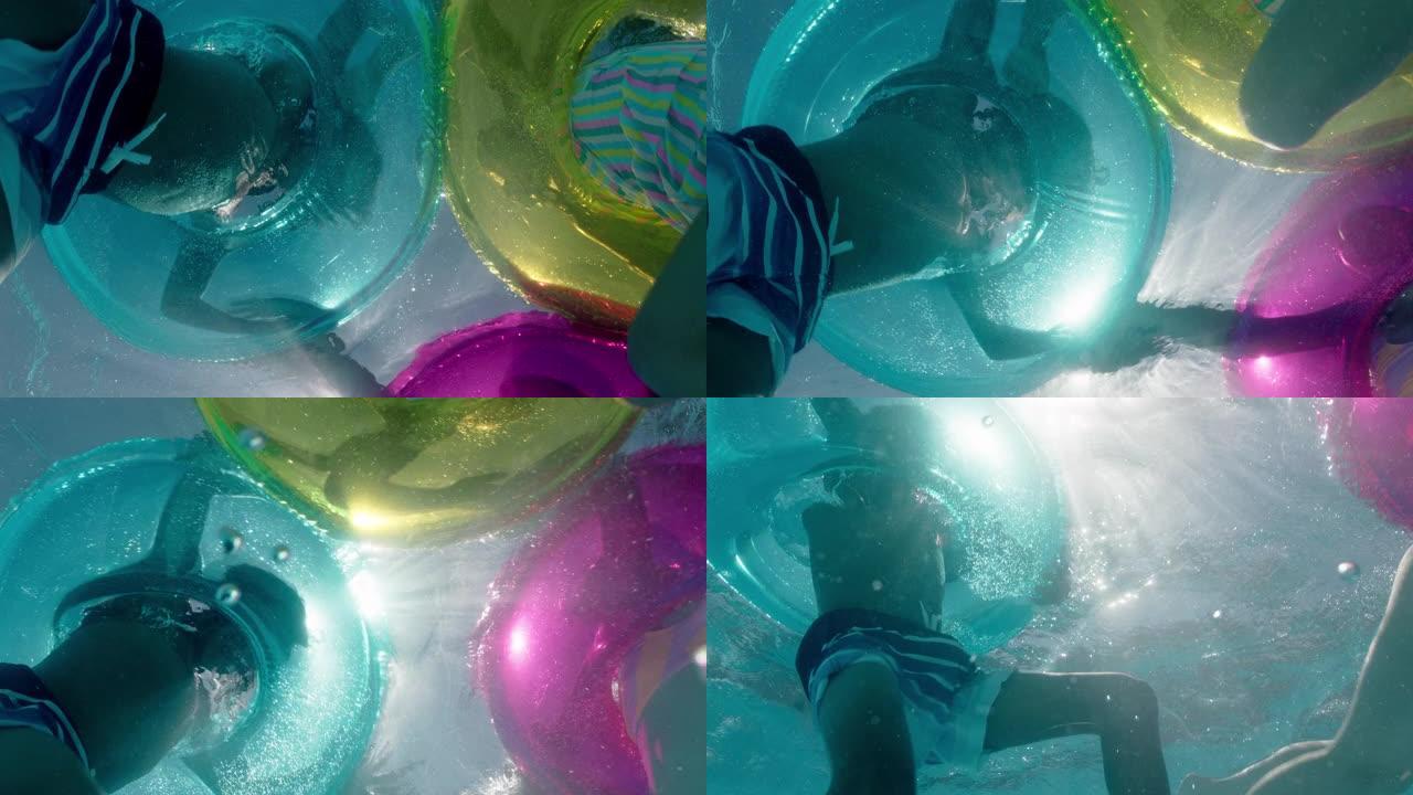 儿童在游泳池里游泳，带彩色游泳管充气玩具嬉戏嬉戏地在水上一起玩乐漂浮着享受暑假水下景观