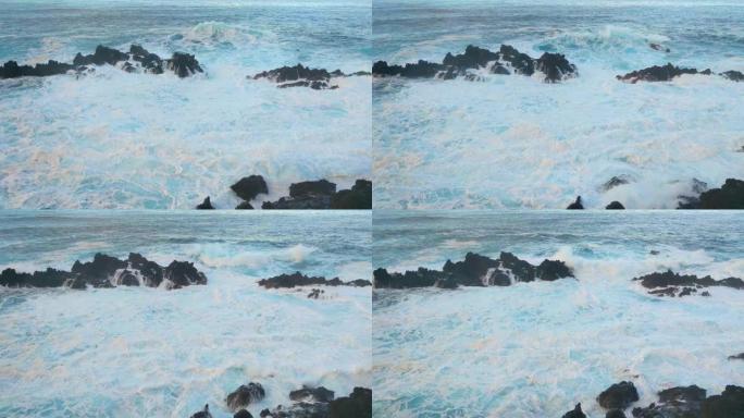 岩石上破浪的慢速运动。白色泡沫。水和波浪的飞溅