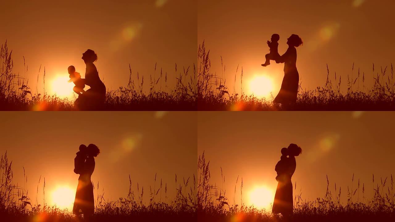 剪影母亲和婴儿日落