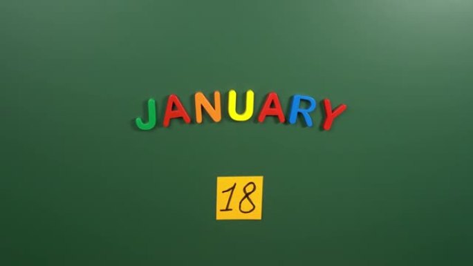 1月18日日历日用手在学校董事会上贴一张贴纸。18 1月日期。1月的第十八天。第18个日期编号。18