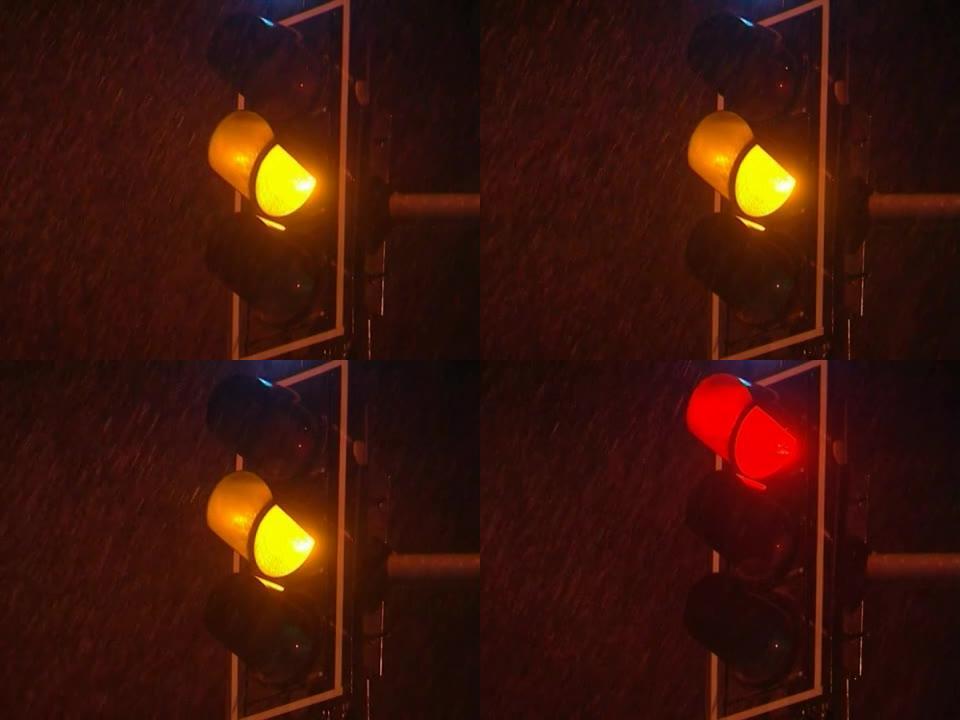 绿色转红色转交通灯雨夜。