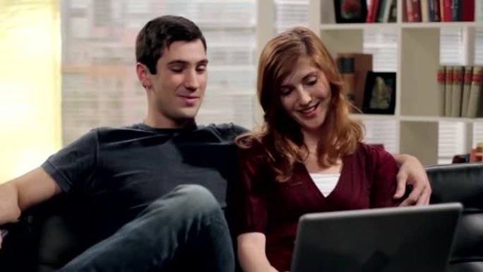 年轻夫妇在笔记本电脑上浏览