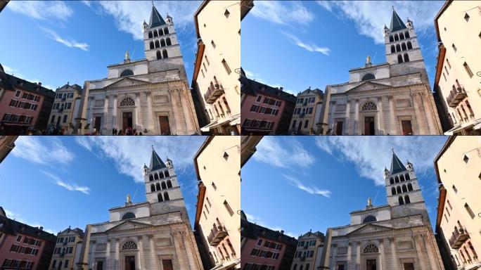法国阿讷西。2023年1月。倾斜镜头，以巴黎圣母院教堂的外墙为证据。美丽的晴天，蓝天白云。广场上的人