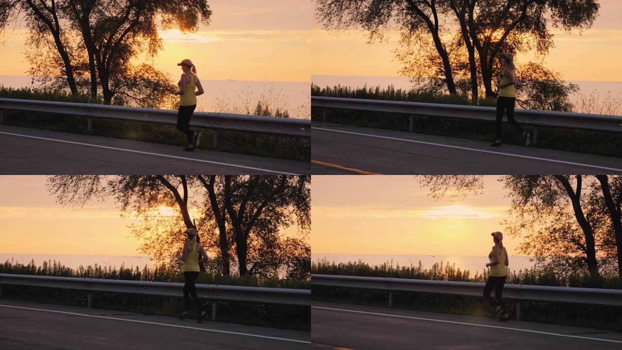 女人在日落时沿着湖边的道路慢跑