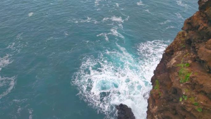 海浪撞击岩石的白色泡沫。从高处观看