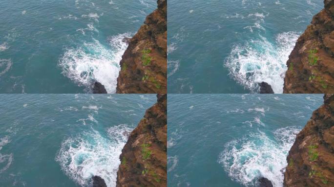 海浪撞击岩石的白色泡沫。从高处观看