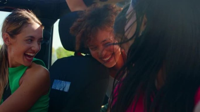 公路旅行中欢笑女性朋友在敞开式汽车中玩耍的垂直视频