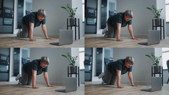 通过互联网上的视频教程在家中训练健康的老年妇女，膝盖站立，手放在地板上