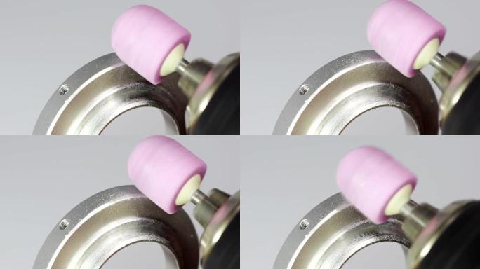 用粉红色研磨机尖端研磨金属零件。