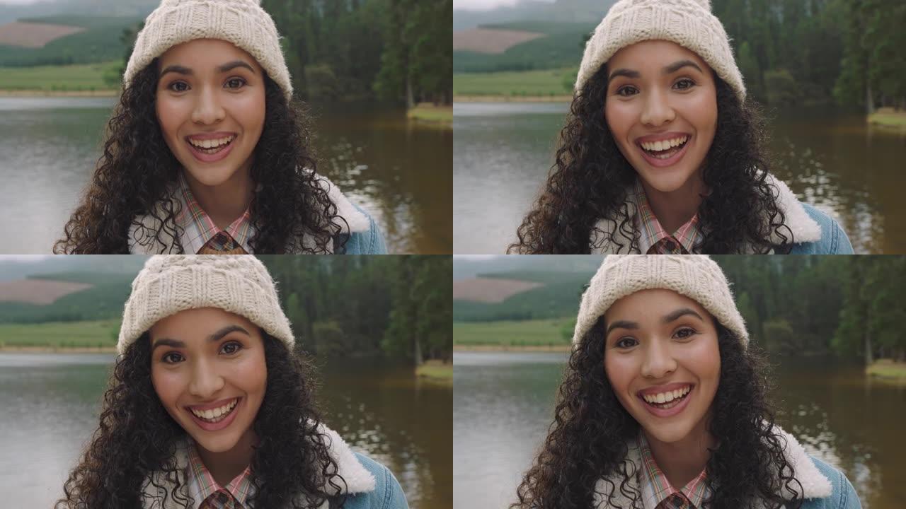 肖像美丽的混血儿女人笑着，看起来很开心，戴着便帽，在大自然的湖边享受寒冷的冬天，真实的人4k