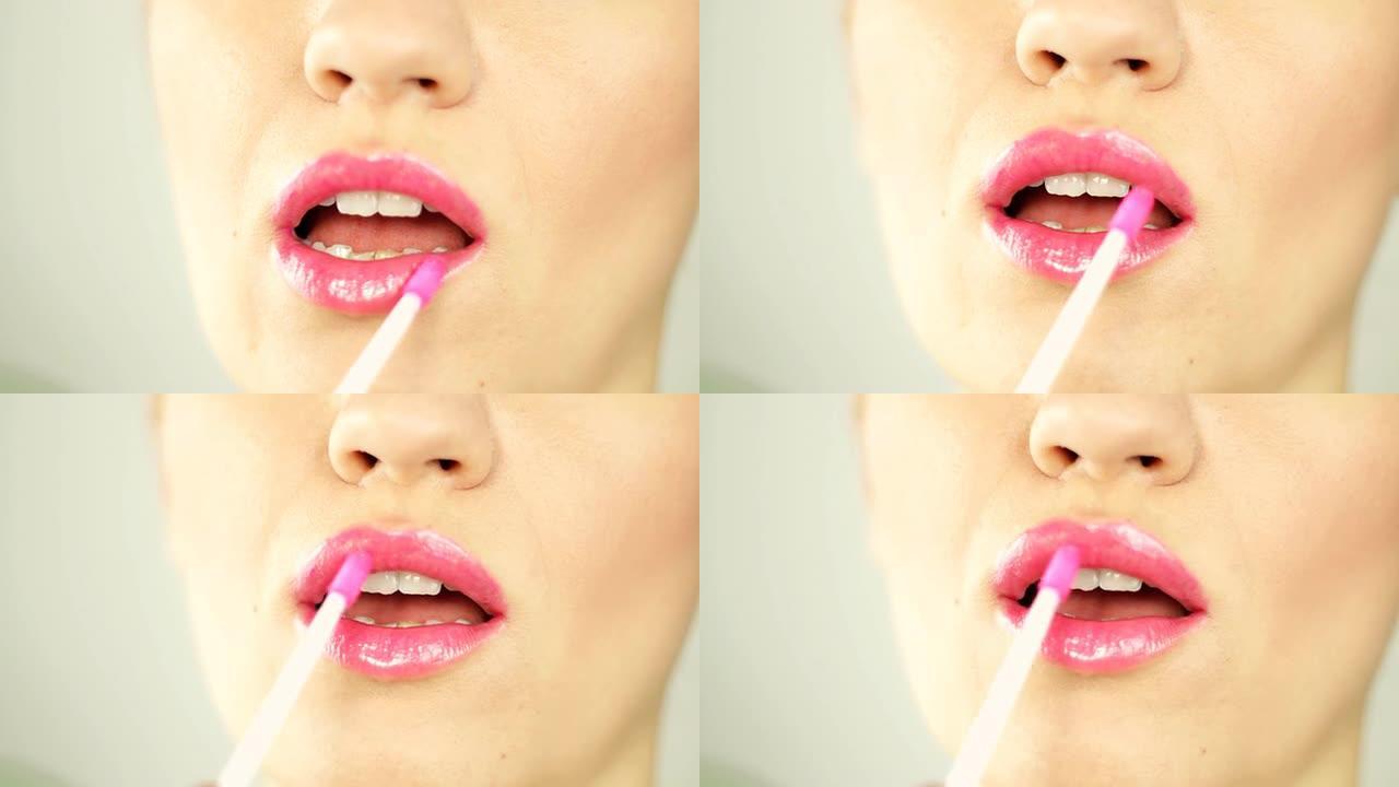 女人在嘴唇上涂抹粉红色唇彩，特写