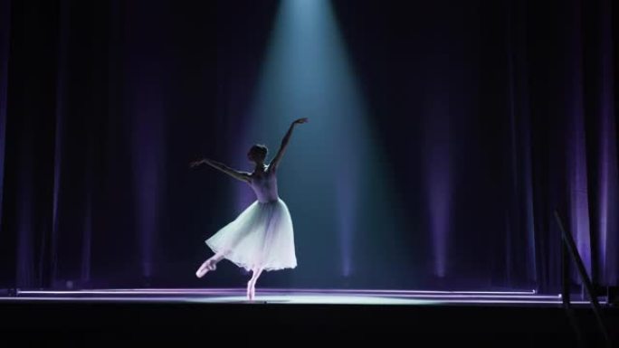 年轻优雅的古典芭蕾舞女舞者在剧院舞台上表演，并带有戏剧性的聚光灯照明。穿着白色芭蕾舞短裙的女人在表演