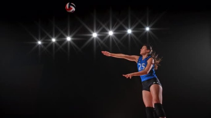 穿着蓝色球衣的SLO MO SPEED坡道女子排球运动员在空中高高击球