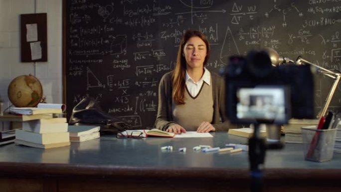 教室里年轻女教师的肖像在黑板前用数学公式远程上课。科学教授在线教学，为她的学生创建电子学习内容